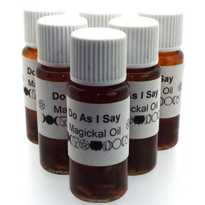 May include: Six small glass bottles with white labels and brown liquid. The labels have black text that reads "Do As I Say Magickal Oil".