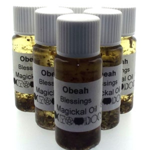 May include: Six small glass bottles with white lids filled with a brown liquid and herbs. The bottles have labels with the text "Obeah Blessings Magickal Oil" and various symbols.
