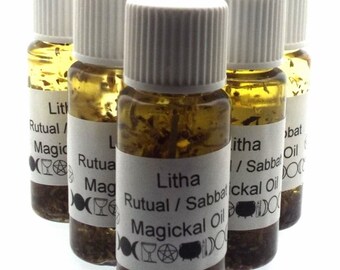 May include: Six small glass bottles with white lids filled with a clear liquid and herbs. Each bottle has a white label with black text that reads "Litha Ritual/Sabbat Magickal Oil".