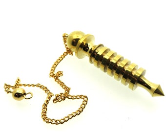 May include: A gold-colored metal pendulum with a pointed tip and a chain. The pendulum has a series of rings around the body.