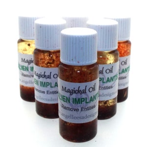 May include: Six small glass bottles with white caps filled with a brown liquid. The bottles have labels that say "Magickal Oil Alien Implants Remove Entities" and "www.angelleesadesigns.com".