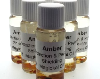 May include: Six small amber glass bottles with white lids. Each bottle contains a clear liquid and small pieces of amber. The labels on the bottles read "Amber Protection & Psychic Shielding Magickal Oil".