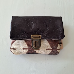 Pequeña y práctica cartera mini confeccionada en tejido interior combinado con piel color violeta oscuro.    Diseño compacto con cierre en color cobre.