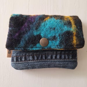 Cartera con exterior de lana afieltrada a mano combinada con jeans reciclados. Preciosa combinación con azul, morado, negro y ocre.