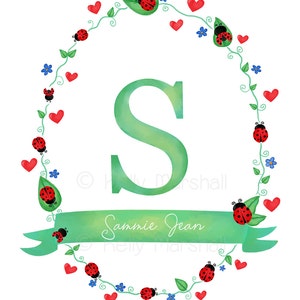 May include: A green letter S surrounded by a wreath of green vines, red hearts, and ladybugs. The wreath is on a white background. The text "Sannie Jean" is written on a green ribbon.