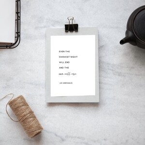 Puede incluir: Una impresión enmarcada en blanco con una cita en blanco y negro del libro Los Miserables: "Incluso la noche más oscura terminará y el sol saldrá."