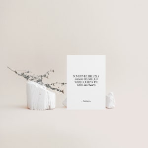 May include: A white card with the text "SOMETIMES THE ONLY miracles WE NEEDED WERE GOOD PEOPLE WITH kind hearts. thank you." is propped up by white stone. A sprig of dried plant life rests on a white block.