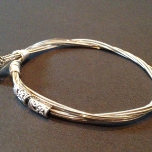 Recycled Guitar String Bracelet, styled with antique style silver beads and silver plated copper wire. Unique Guitarist Gift