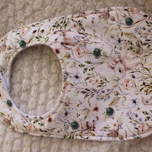Op de afbeelding: Een witte slab met een bloemenpatroon met konijnen en bloemen. De slab heeft een groene, roze en blauwe kleurstelling.
