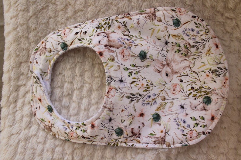 Op de afbeelding: Een witte slab met een bloemenpatroon met konijnen en bloemen. De slab heeft een groene, roze en blauwe kleurstelling.