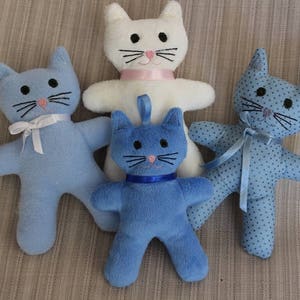 May include: Four plush cat toys. One white cat with pink accents, one blue cat with white accents, one blue cat with white polka dots, and one blue cat with a blue ribbon.