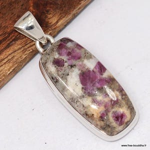 May include: A rectangular pendant with a silver bail and setting. The pendant features a polished stone with a mix of colors, including white, gray, and vibrant pink. The stone has a speckled appearance and is set in a polished silver frame.