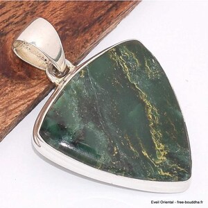 Peut inclure: Un pendentif triangulaire avec une bélière et un cadre argentés. Le pendentif présente une pierre vert foncé avec des veines dorées et noires. La pierre est sertie dans un cadre argenté poli. Le pendentif est présenté sur une surface en bois.