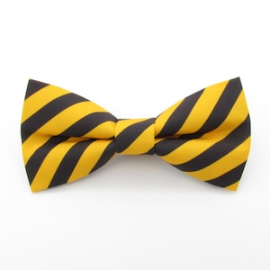 Peut inclure: Un nœud papillon rayé jaune et noir. Le nœud papillon est fait d'un tissu lisse et a une forme classique.