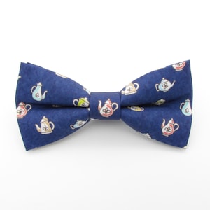 May include: A navy blue bow tie with a pattern of colourful teapots.