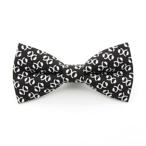 May include: A black bow tie with a white geometric pattern.