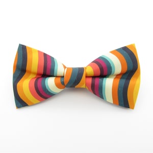 May include: A colourful bow tie with a striped pattern in shades of orange, yellow, blue, green, and red.