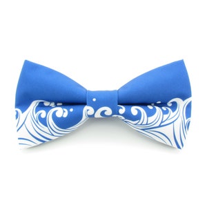 May include: A blue bow tie with a white wave pattern.