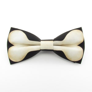 May include: A black bow tie with a white bone design.