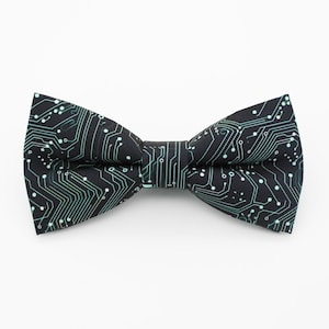 Può includere: Un papillon nero con un motivo a circuito verde.