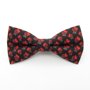 May include: A black bow tie with a red boxing glove pattern.