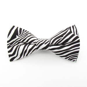 May include: A black and white zebra patterned bow tie.