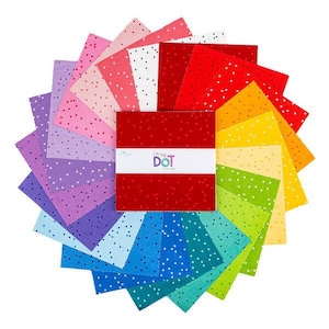 May include: A colorful fabric bundle with a variety of square fabric pieces arranged in a circular pattern. The fabrics are in shades of red, orange, yellow, green, blue, purple, and pink, each with white polka dots. The bundle is wrapped with a white band that reads "ON THE DOT".
