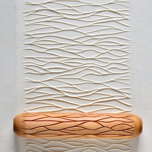 May include: A wooden rolling pin with a carved wavy pattern. The rolling pin is used to create a decorative pattern on dough or clay.