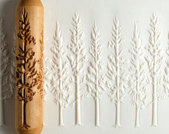 May include: A wooden rolling pin with a carved design of a forest of pine trees. The rolling pin is approximately 6 inches long and 2 inches in diameter.