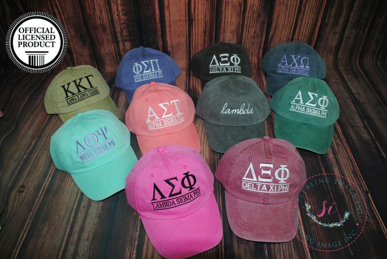 Puede incluir: Nueve gorras de b&eacute;isbol de diferentes colores con varias letras griegas y nombres bordados en ellas. Las gorras est&aacute;n hechas de un material suave y c&oacute;modo y son perfectas para mostrar el esp&iacute;ritu de tu escuela.