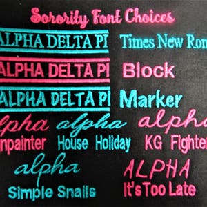 Puede incluir: Un fondo negro con el texto "Sorority Font Choices" en rosa. El texto "ALPHA DELTA PI" se muestra en varias fuentes, incluidas Times New Roman, Block y Marker. Otras fuentes incluyen Signpainter, House Holiday, KG Fighter, Simple Snails y It's Too Late.