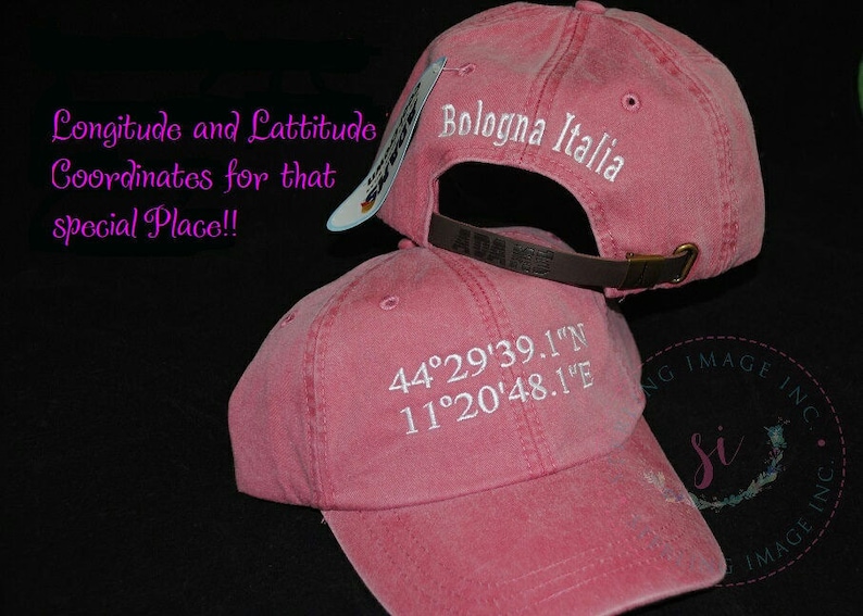 May include: Two pink baseball caps with white embroidery. The top cap says "Bologna Italia". The bottom cap says "44&deg;29'39.1"N 11&deg;20'48.1"E".