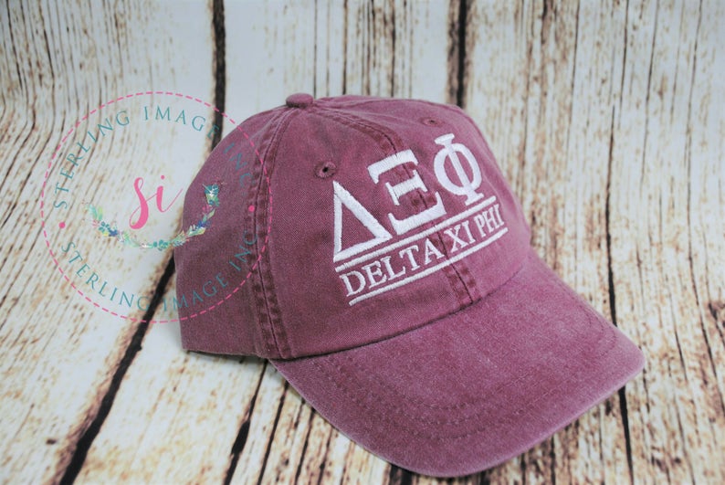 Puede incluir: Una gorra de b&eacute;isbol de color granate con bordado blanco que dice "&Delta;&Sigma;&Phi; Delta Xi Phi".