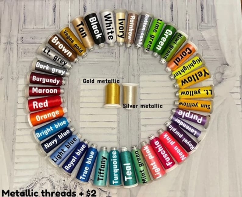 May include: A variety of embroidery floss spools arranged in a circle, with colors including black, white, ivory, rainbow, cotton candy, lime green, green, kiwi green, coral, highlighter yellow, light yellow, sun yellow, purple, lavender, royal purple, neon pink, fuchsia, light pink, mint green, teal, turquoise, tiffany, true blue, royal blue, light blue, navy blue, bright blue, orange, red, maroon, burgundy, dark grey, light grey, brown, tan, vegas gold, gold metallic, and silver metallic. The text "Metallic threads + $2" is at the bottom of the image.