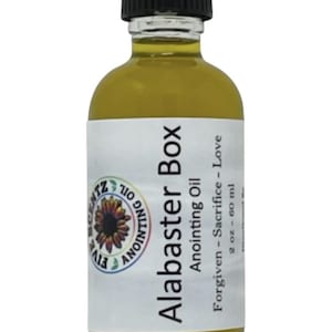 Könnte beinhalten: Eine durchsichtige Glasflasche mit schwarzem Deckel, gefüllt mit einer gelben Flüssigkeit. Das Etikett lautet "Alabaster Box Anointing Oil Forgiven - Sacrifice - Love 2 oz - 60 ml".