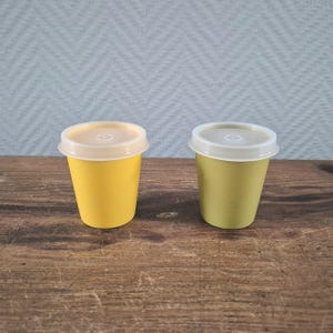 以下が含まれることがあります： ふた付きの小さなプラスチック容器が2つ。1つは黄色、もう1つは緑色です。