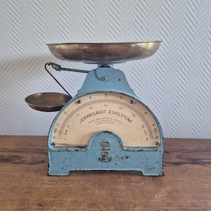 Puede incluir: Balanza de cocina vintage azul y latón con esfera circular y un plato pequeño. La balanza tiene un cuenco de latón y un plato más pequeño de latón. El dial dice "JERNBOLAGET ESKILSTUNA".