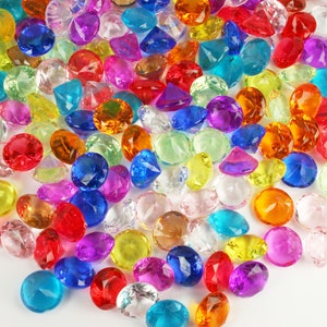 May include: A large pile of colorful plastic gems in various shapes and sizes. The gems are scattered on a white background.