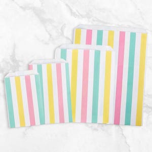 May include: Four paper treat bags in varying sizes, arranged from smallest to largest. Each bag features vertical stripes in pastel colors: pink, yellow, and teal, alternating with white stripes. The bags are made of paper and have a folded top.