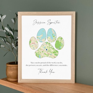 May include: A framed print featuring a paw print design composed of map segments. The print includes the name "Jessica Spartan" in cursive, along with an inspirational quote and the words "Thank You."