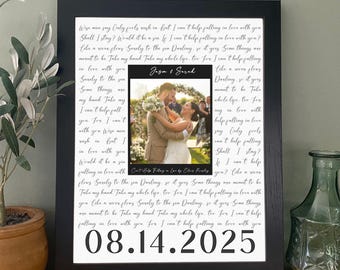 May include: A framed wedding photo print with a black frame. The photo features a couple embracing. The print includes the names "Jasm & Sarah" and the date "08.14.2025". The background has a handwritten style quote.