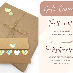 May include: A brown paper package with a brown envelope tied with twine. The envelope has a white heart with the letters "L+L" on it and several small hearts with map designs. The text "Gift Options" is in a pink rectangle at the top of the image. The text "To add a card" and "LINK IS IN THE ITEM DESCRIPTION!" is below the rectangle. The text "To add gift-wrapping" and "CHOOSE "THIS ITEM IS A GIFT" WHEN CHECKING OUT" is below the card text.