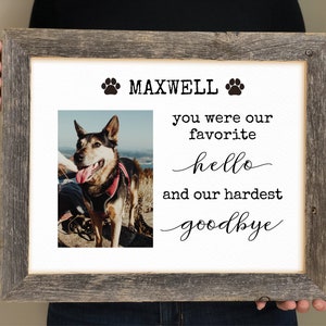 May include: A framed photo memorial for a dog named Maxwell. The photo shows a brown and black dog with its tongue sticking out. The text reads "Maxwell you were our favorite hello and our hardest goodbye".