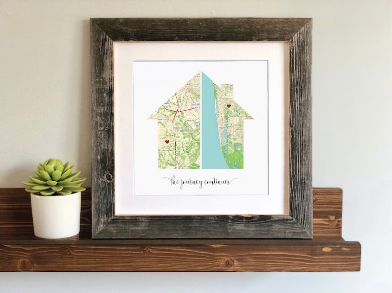 May include: A framed print of a house made from two maps with red hearts marking locations. The text "the journey continues" is printed below the house.