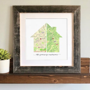 May include: A framed print of a house silhouette made from two maps. The house is divided in half, with each half showing a different map. The text "The journey continues" is printed below the house.