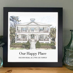 May include: A black framed print of a house with a white exterior and a gray roof. The house has a porch on the front and a staircase leading up to the front door. The print has the text "Our Happy Place" and "Hilton Head, SC | The Lee Family" below the image.