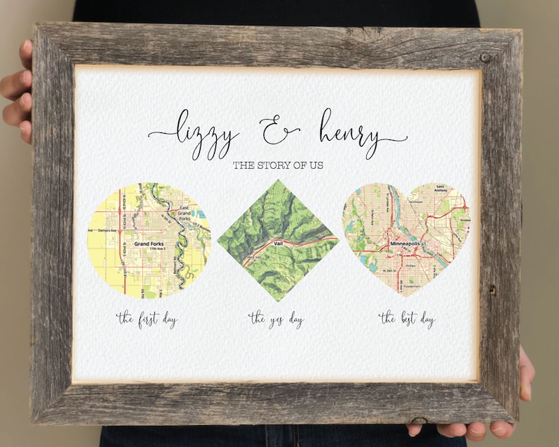 May include: A framed print with a white background and three maps. The maps are in a circle, diamond, and heart shape. The text "Lizzy & Henry" is at the top of the print. The text "The Story of Us" is below the names. The text "The first day", "The yes day", and "The best day" are below the maps.