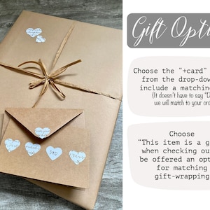 May include: A brown paper package with a brown ribbon tied around it. The package is decorated with small white heart-shaped stickers that say "Love you more than words can hold". A smaller brown envelope is on top of the package with more heart stickers that say "Love you more than words can hold" and "Dad". The text "Gift Options" is in a gray box. The text "Choose the "+card" option from the drop-down to include a matching card {It doesn't have to say "Dad," we will match to your order}" is in a white box. The text "Choose "This item is a gift" when checking out to be offered an option for matching gift-wrapping" is in a white box.