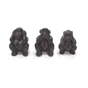 May include: Three black monkey figurines, each covering a different sense: one covers its eyes, one covers its ears, and one covers its mouth.