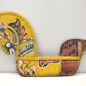 Op de afbeelding: Een gele, rode en blauwe kralenpaardenkop met een lange staart van bruin haar. Het paard is een traditioneel handwerk van de Amerikaanse Indianen.